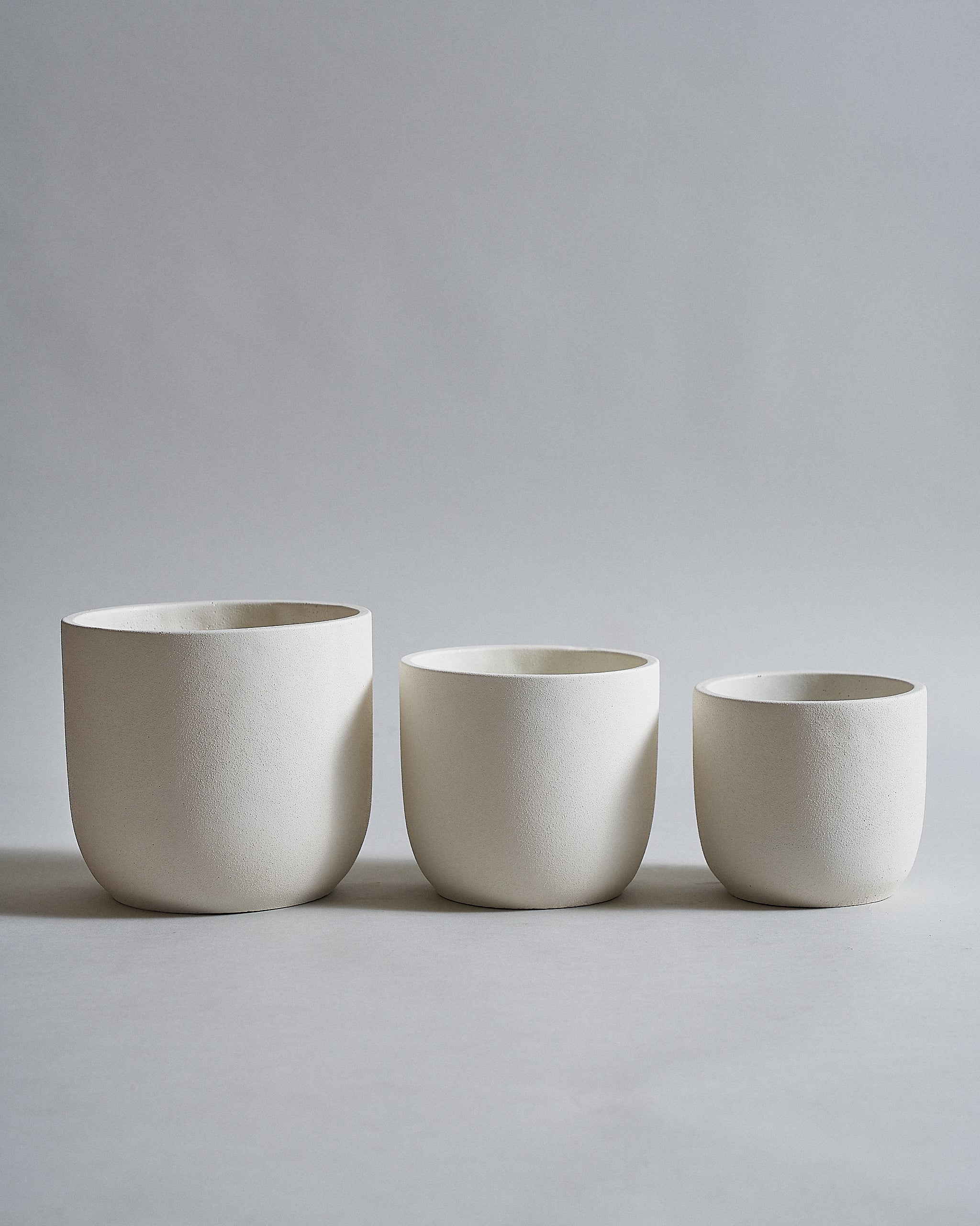 White concrete pot for indoor plants with a rounded bottom design