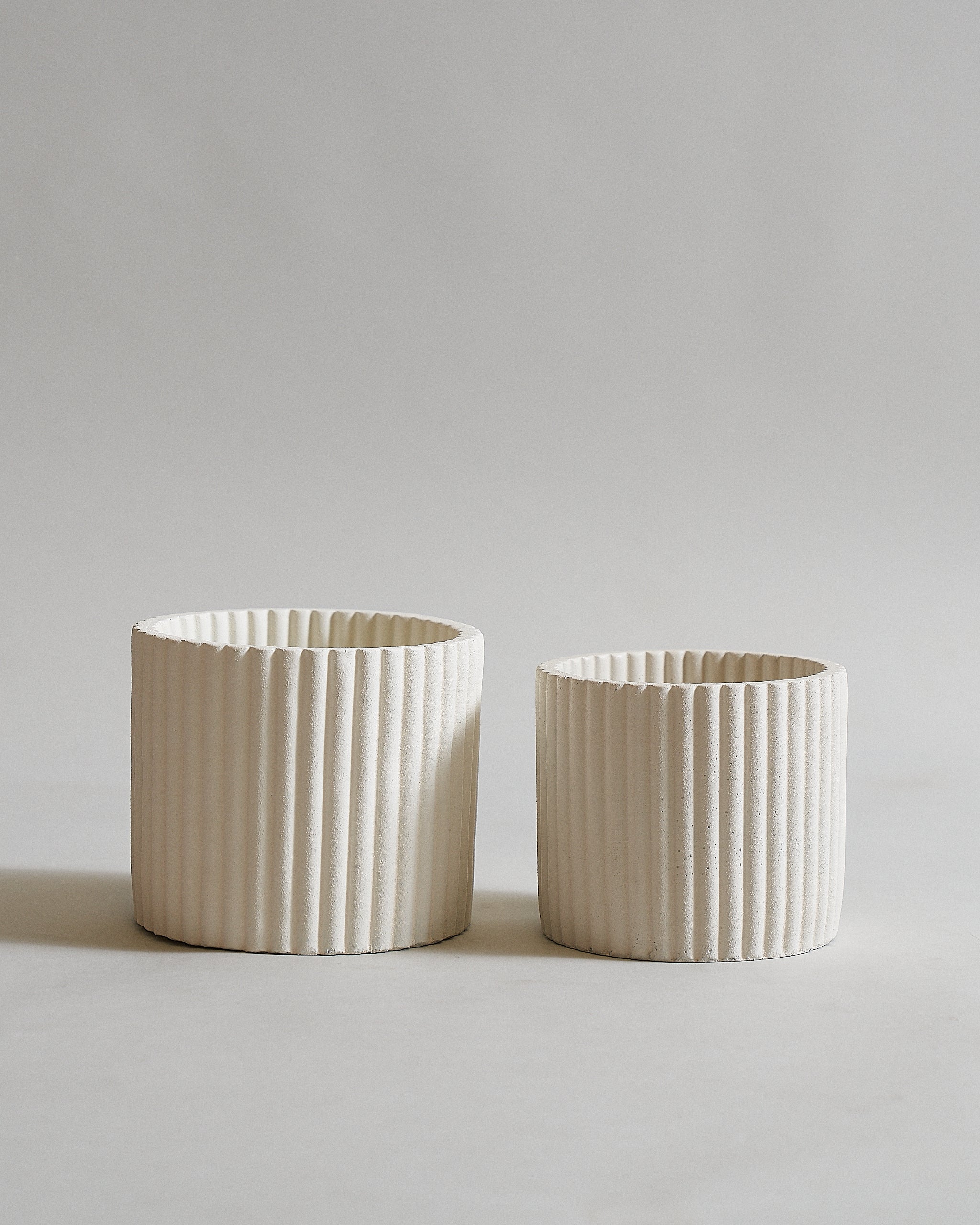 White concrete pot for indoor plants with a fluted design